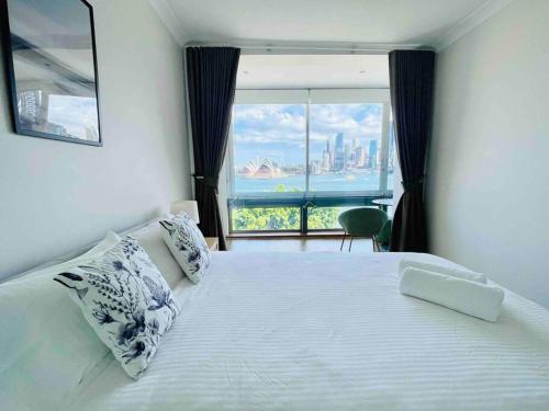 a bedroom with a large bed with a large window at Opera & Harbour bridge view penthouse (3 rooms) in Sydney
