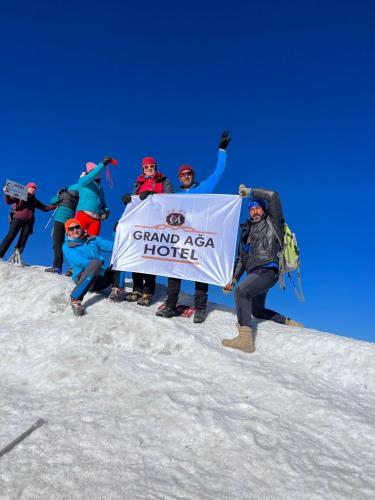 un grupo de personas sosteniendo un cartel en una montaña en GRAND AĞA HOTEL, en Doğubayazıt