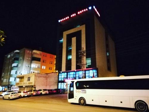 un autobús blanco estacionado frente a un edificio por la noche en GRAND AĞA HOTEL, en Doğubayazıt