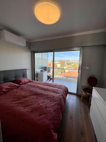 une chambre avec un grand lit et une grande fenêtre dans l'établissement Cannes Santa Catalina, à Cannes