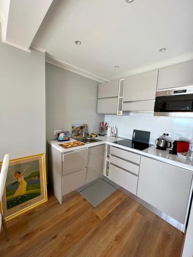 une cuisine avec des armoires blanches et un comptoir dans l'établissement Cannes Santa Catalina, à Cannes