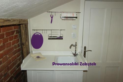 uma casa de banho com um lavatório branco e uma parede de tijolos em Domek Podróżniczy em Lódź