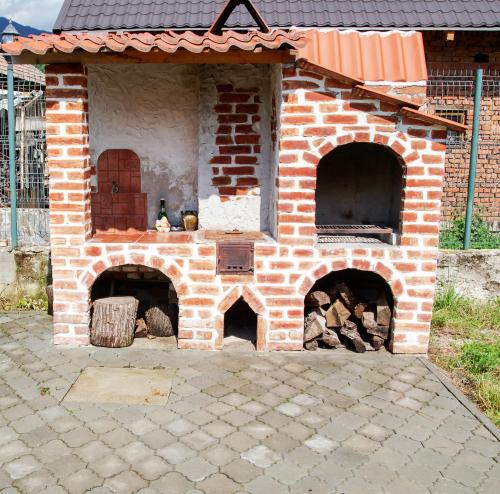 an outdoor brick oven with two entrances and a door at Casa Matteo in Arefu