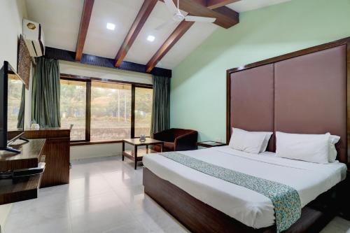 a bedroom with a bed and a desk and a piano at Amazinn Villa in Lonavala