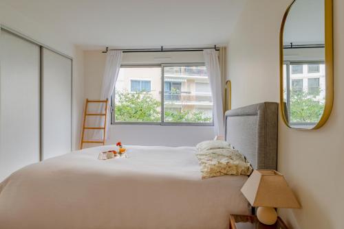 une chambre avec un grand lit et un miroir dans l'établissement Paris Arsonval Design Residence, à Paris