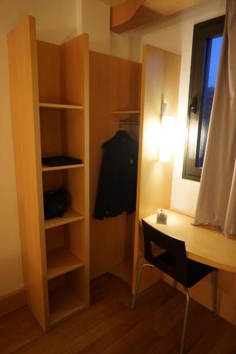a room with a desk and a closet at Ibis Girona in Girona