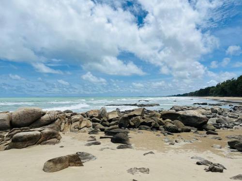 a beach with rocks on the sand and the ocean at BEACH FRONT modern room + Free hi speed Wi-Fi in Ban Chak Phai