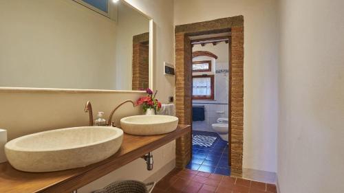 ein Badezimmer mit zwei Waschbecken auf einer Holztheke in der Unterkunft Colombaio di Montebenichi in Bucine
