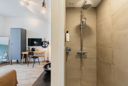 a bathroom with a shower and a bed and a desk at Eye Hotel in Utrecht