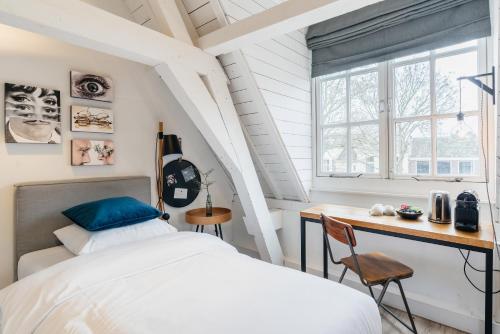 um quarto com uma cama e uma secretária em Eye Hotel em Utrecht