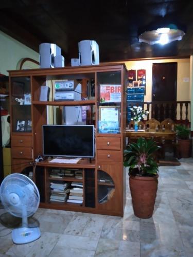 a room with a desk with a computer and a fan at Camille's Cheapstay in Alaminos