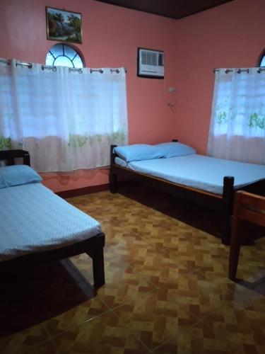 a room with two beds and a window at Camille's Cheapstay in Alaminos