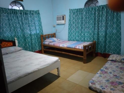 a small room with two beds and a radiator at Camille's Cheapstay in Alaminos