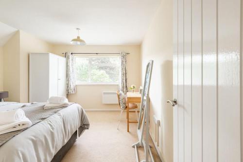 Un dormitorio con una cama y un escritorio y una ventana. en Lovely Town Centre 1 Bed Nr Country & River Walks, en Gloucestershire