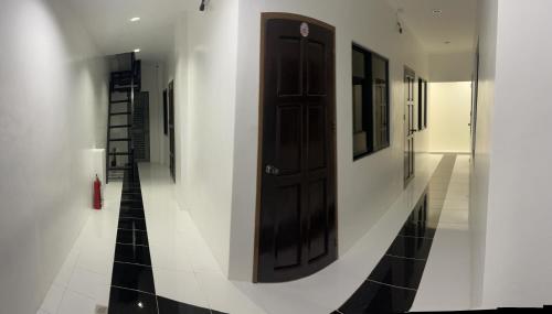 a hallway with a black door on a white wall at Calo apartel in Panabo