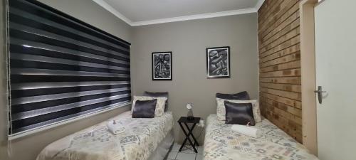 a bedroom with two beds and a wooden headboard at Tenuta Overnight in Polokwane