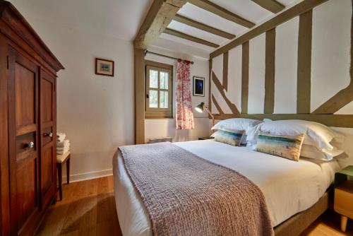 une chambre avec un grand lit dans une pièce dans l'établissement La Maison Blanche du 10Honfleur, à Honfleur