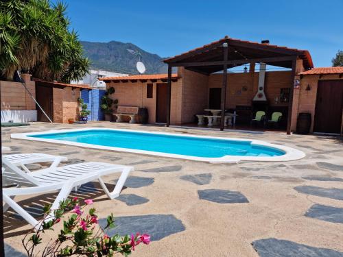 una piscina con 2 sillas y una casa en CASA LA MOLINETA, en Arafo