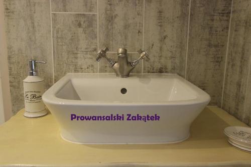 a white sink with a faucet on a counter at Domek Podróżniczy in Łódź