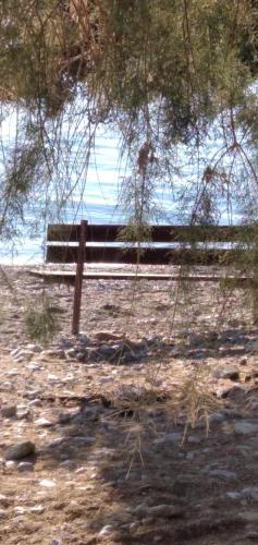 a bench in a field with the ocean in the background at Geranium Villa by the sea in Kineta