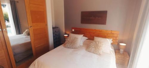 a bedroom with a white bed with two pillows at Villa SOREDE in Sorède