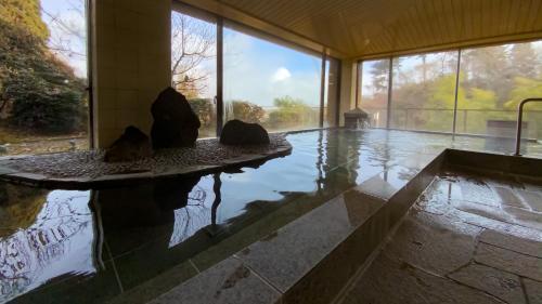 una habitación con una piscina de agua en una casa en Breezbay Seaside Resort Matsushima, en Matsushima