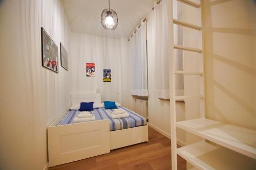 Un pequeño dormitorio blanco con una cama y una escalera en Le robbiane 44 - 46, en Florencia