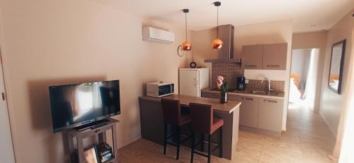 eine Küche mit einem Tisch und einem TV im Zimmer in der Unterkunft Villa SOREDE in Sorède