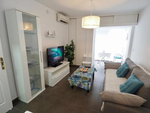 sala de estar con sofá y TV en A 10 min de la playa y con excelentes zonas comunes, en Benalmádena