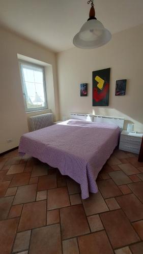 a bedroom with a large bed with a purple blanket at Casa Lilla in Bellagio