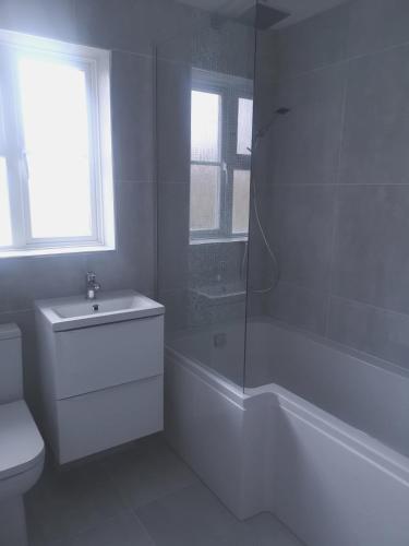 a white bathroom with a shower and a toilet at BIENVENUE in NEWHAVEN Luxury superking OR standard OR budget rooms in Newhaven