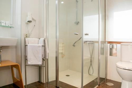 a bathroom with a shower and a toilet at Hotel Dabeleira in Luarca