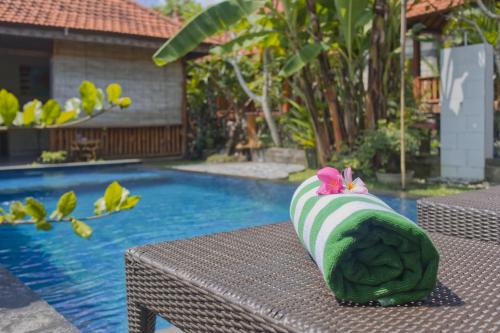 una almohada verde sentada en una mesa junto a una piscina en SS Pangket Bungalow, en Nusa Penida