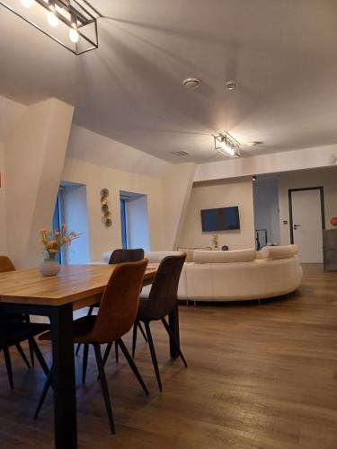 a living room with a table and chairs and a couch at Au bout de mes rêves in Walcourt