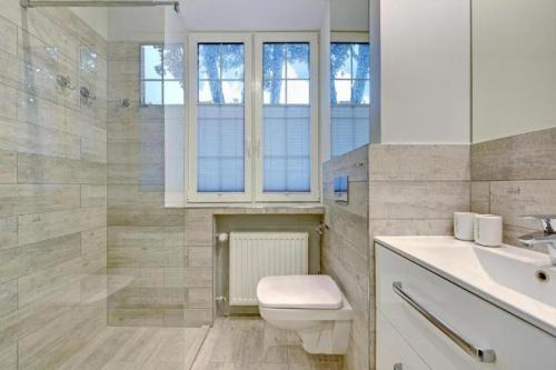 a bathroom with a toilet and a sink at UrbanNestGroup & Sw35/36 in Gdańsk
