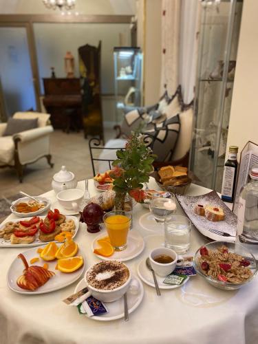 a table topped with plates of food and fruit at Hotel Akropolis - Museum Hotel in Taranto