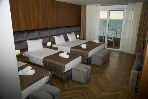 een hotelkamer met 2 bedden en een balkon bij Twin Towers Hotel City & Beach Resort in Shëngjin