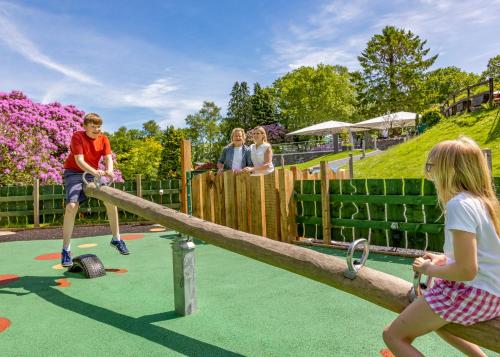 a boy and a girl playing on a log playground at Aberdunant Hall Holiday Park in Porthmadog