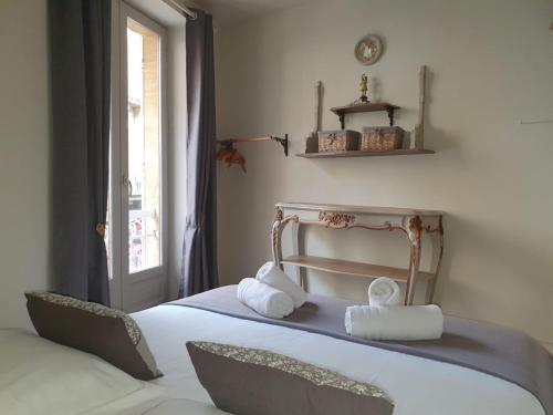 une chambre avec un lit avec deux animaux en peluche dessus dans l'établissement À l'époque, à Sarlat-la-Canéda