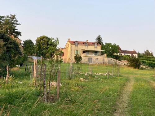a house on top of a field with a dirt road at Rez-de-jardin 3 pièces avec jolie vue in Plazac