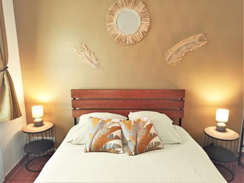 a bedroom with a bed with two tables and two mirrors at AC - Quiet - Le Colibri, Bright Duplex in Avignon