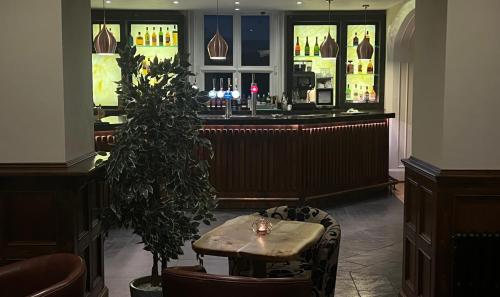 a restaurant with a table and a bar at Aberdunant Hall Holiday Park in Porthmadog
