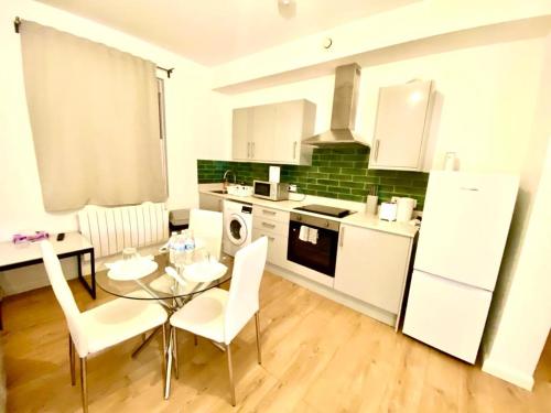a kitchen with a glass table and white appliances at One Bedroom Apartment In Ealing London in Ealing