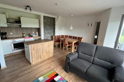 cocina y sala de estar con sofá y mesa en Ferienwohnung am Bauernhof, en Wald