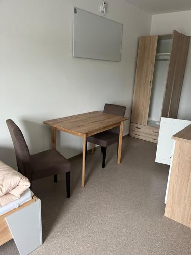 Zimmer mit einem Holztisch und einem Stuhl in der Unterkunft Zimmervermietung Asten in Linz