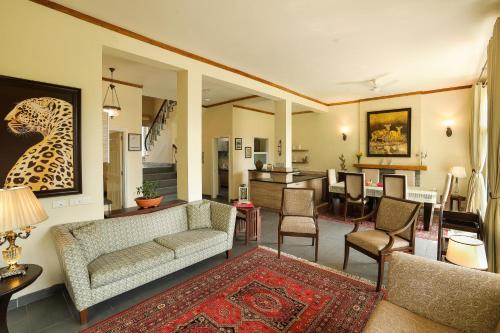帕拉姆普爾的住宿－Lamrin Norwood Green Palampur, Himachal Pradesh，带沙发的客厅和用餐室