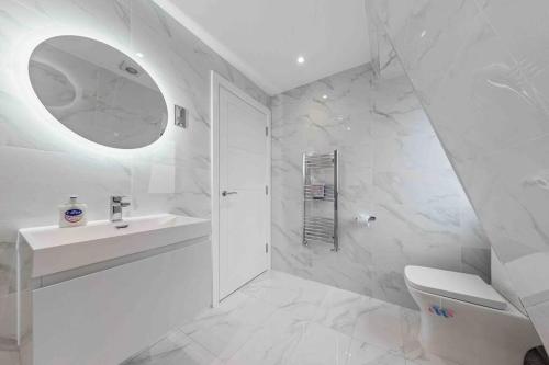 La salle de bains blanche est pourvue d'un lavabo et de toilettes. dans l'établissement Serviced Apt in central London LR3, à Londres