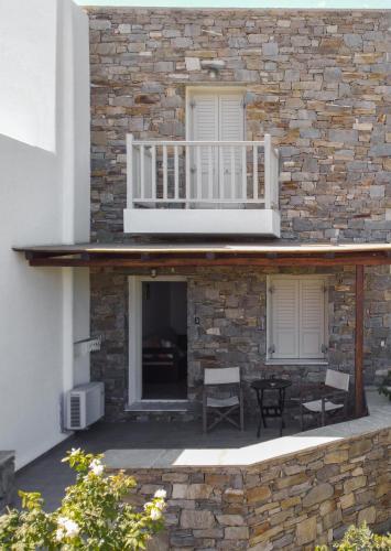 a stone building with a balcony and a patio at Palos Studios in Livadion