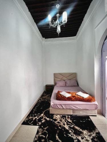 een slaapkamer met een bed en een plafond met een kroonluchter bij Riad Yamna in Rabat