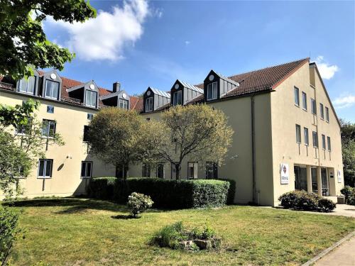 un gran edificio con un patio delante en Hotel Havelland by PRIMA, en Götz